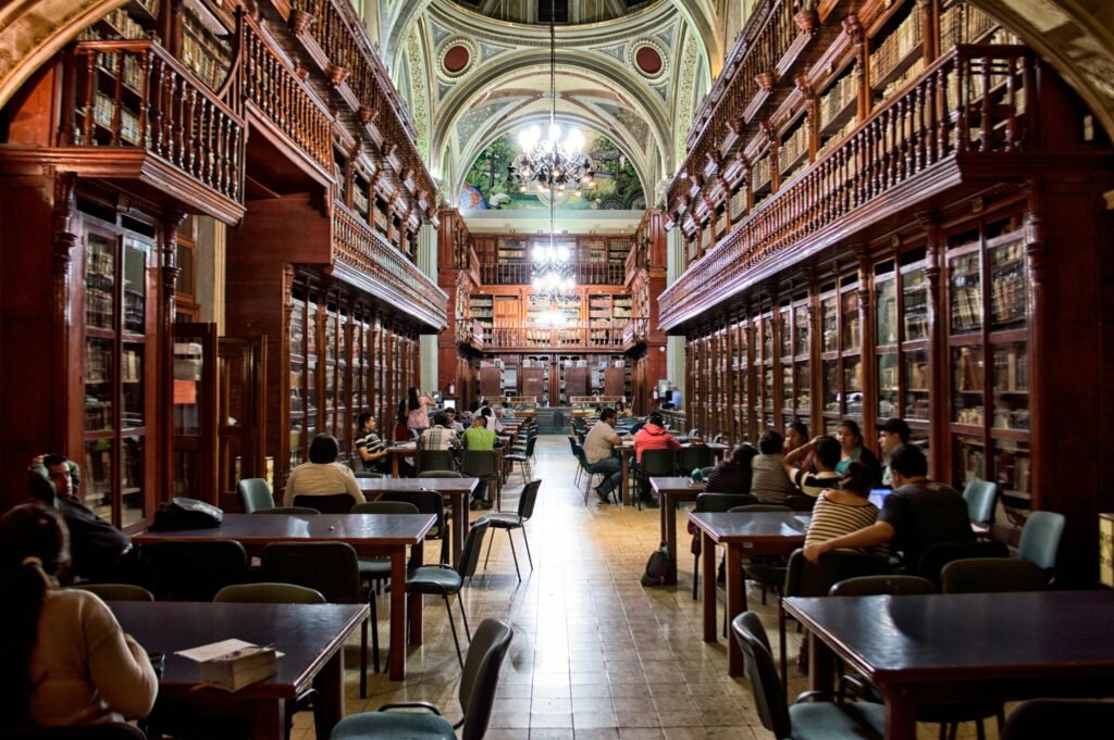 Elegant library with people studying, surrounded by wooden shelves and classical architecture.