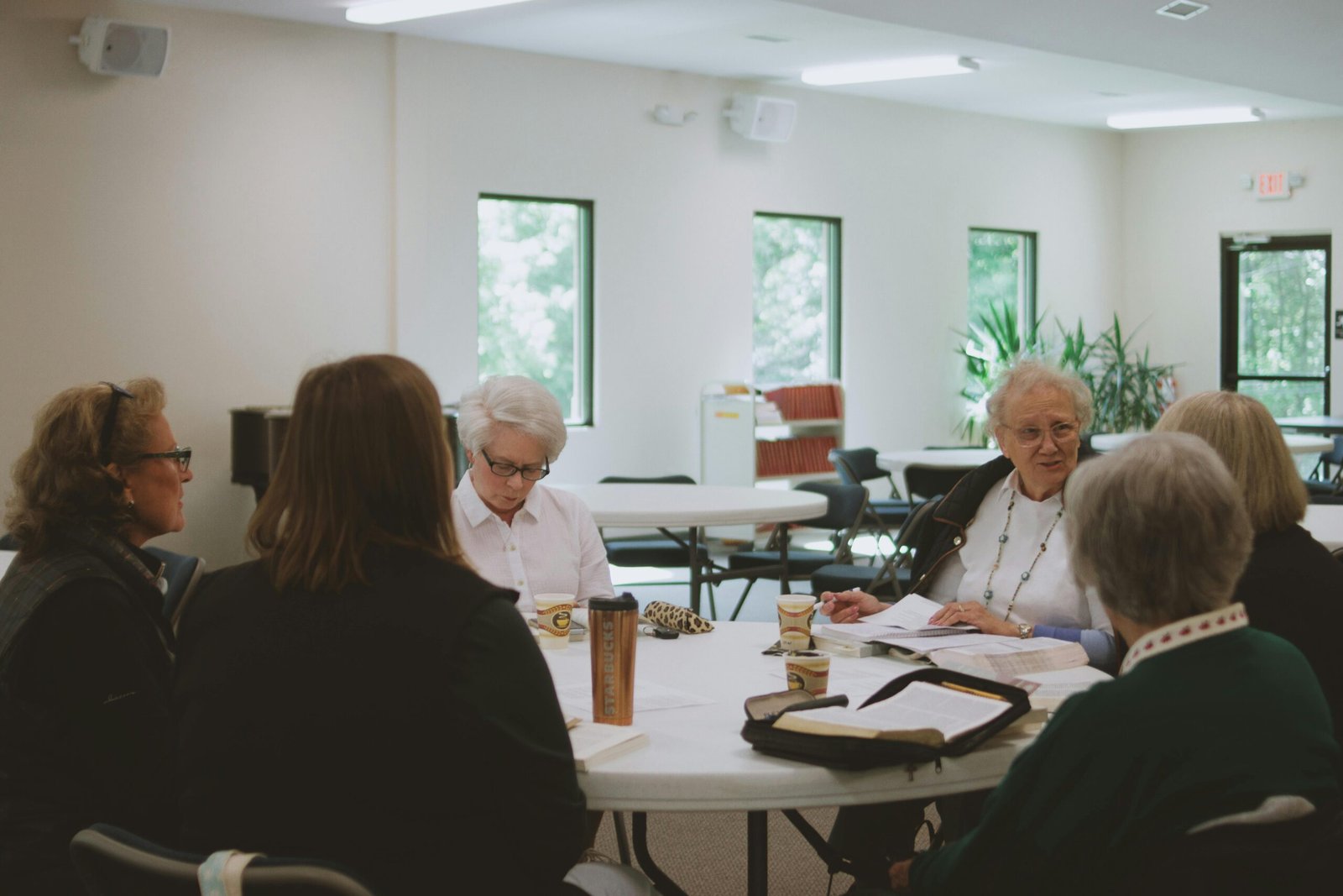 VOLUNTARIADO Group of women participating in a Bible study session indoors, fostering community and spiritual growth.